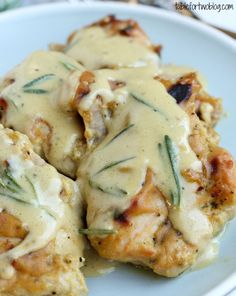 some chicken covered in gravy on a white plate