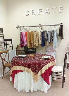 a table with a red and white cloth on it in front of a sign that says create