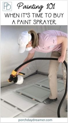 a woman using a paint sprayer on the floor