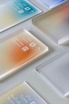 an array of different colored glass plates sitting on top of each other in front of a white background