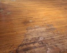 a wooden floor that has been cleaned and is brown with some dirt on the top