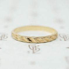 a gold wedding ring sitting on top of a table