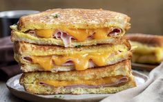 two grilled cheese sandwiches stacked on top of each other with ham and cheese in the middle