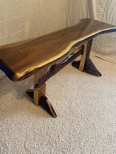 a wooden bench sitting on top of a carpeted floor