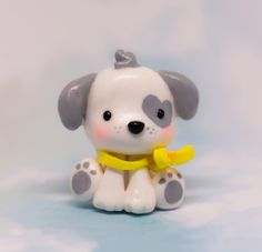 a small toy dog with a yellow ribbon around its neck