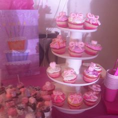 three tiered cupcake display with pink and white decorations