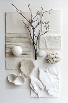 an arrangement of white and gray art work with eggs, branches, and other items