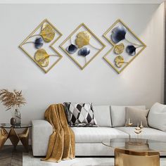 a living room with white couches and gold accents on the wall above them is a coffee table