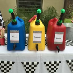 three different colored jugs with labels on them sitting on a checkered table cloth