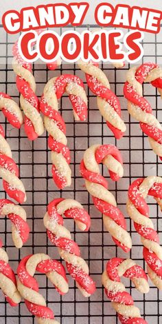 candy cane cookies on a cooling rack with red and white sprinkled icing