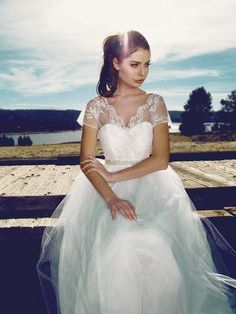 a woman in a white dress sitting on a bench