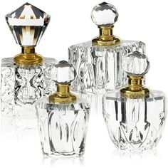 three clear glass jars with gold trimmings on top and one has a diamond in the middle