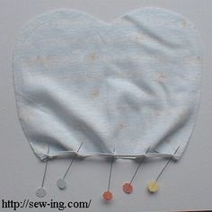 a cloth heart with pins attached to it