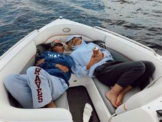 two people laying on the back of a boat