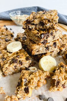 granola bars stacked on top of each other with bananas and chocolate chips around them