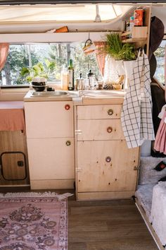 the inside of a camper with lots of clutter and things hanging out to dry