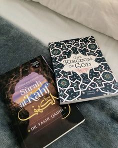 two books sitting on top of a bed next to each other in front of a pillow