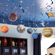 the ceiling in this room is decorated with planets and stars hanging from it's ceiling