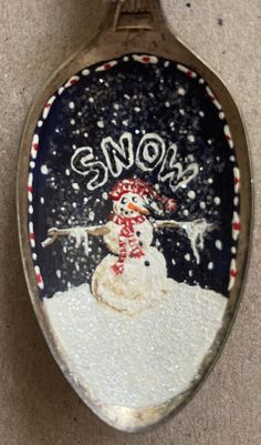 a spoon with a snowman painted on it