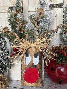 a wooden block with a reindeer's head on it next to two christmas trees