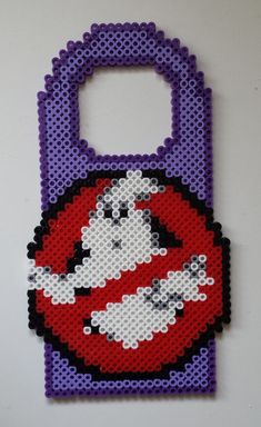 a bag made out of legos on a white surface with a purple handle and red lips