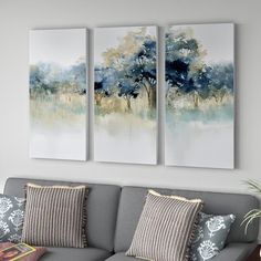 two paintings on the wall above a couch in a living room with pillows and throw pillows