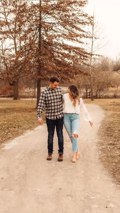 a man and woman walking down a dirt road