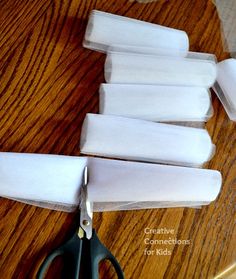 scissors and white fabric on a wooden table