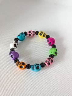 This eye-catching bracelet features an array of brightly colored plastic beads, interspersed with striking skull accents. The combination of vivid colors and edgy skulls creates a fun and unique accessory that stands out. Made with durable materials, this bracelet is both lightweight and comfortable to wear. Ideal for those who love quirky and distinctive jewelry, this bracelet is versatile enough to complement both casual and trendy outfits. Add this Multi-Colored Plastic Bead Skull Bracelet to Multicolor Novelty Wristband Bracelet, Halloween Multicolor Beaded Bracelets, Novelty Multicolor Beaded Bracelets For Halloween, Halloween Novelty Multicolor Beaded Bracelets, Multicolor Skull Jewelry For Day Of The Dead, Day Of The Dead Multicolor Skull Jewelry, Novelty Multicolor Bracelets For Festival, Novelty Multicolor Beaded Festival Bracelets, Novelty Multicolor Festival Bracelets