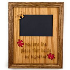 a wooden frame with puzzle pieces and the words you are the piece that holds us together