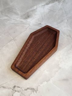 a wooden tray sitting on top of a marble countertop next to a white wall