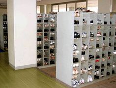 there are many pairs of shoes on display in this room, all lined up against the wall