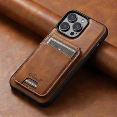 an iphone case with a card slot in the middle on top of a brown leather surface