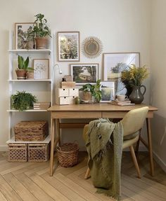 a wooden desk topped with lots of potted plants next to a shelf filled with pictures