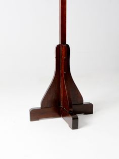 a small wooden table with a clock on it's top and two legs in the middle