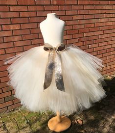 "This listing includes an ivory and champagne/beige tutu with a gold glitter bow. This listing if for waist sizes up to 34 1/2\" can be made larger if interested contact me for a special listing. Other colors also available. The ivory and champagne/beige tutu pictured is the 19-24\" length range with a longest layer of 20\" and top layer of 17\". Tutu can be all one length or the dual lengths. **please just note the length you would like or lengths you would like upon checkout Thank you for shop Maternity Tutu, Adult Tutu Skirt, Bachelorette Tutu, Adult Tulle Skirt, Adult Cake Smash, Gold Glitter Bow, Newborn Tutu, Kids Tutu, Rainbow Tutu