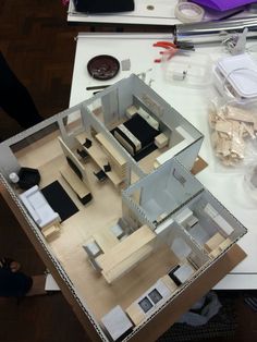 an overhead view of a model house on a table with tools and other items around it