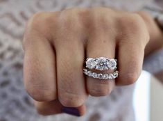 a woman's hand with two engagement rings on it