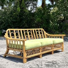 a wooden bench sitting on top of a cement ground next to trees and bushes in the background