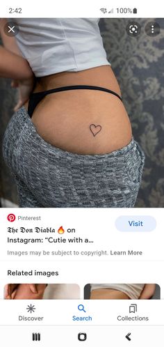 the back of a woman's stomach with a heart tattoo on it