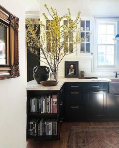 a kitchen with black cabinets and white walls