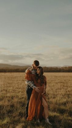 a man and woman embracing in an open field