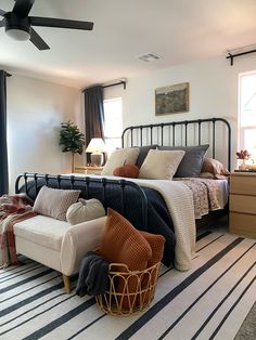 a bed room with a neatly made bed next to a window and a chair in front of the bed