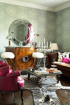 a living room filled with furniture and a zebra print rug on top of a hard wood floor