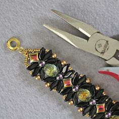 a pair of scissors and some beads on a table