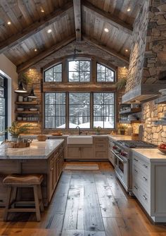 a large kitchen with wood floors and stone walls, along with an island in the middle