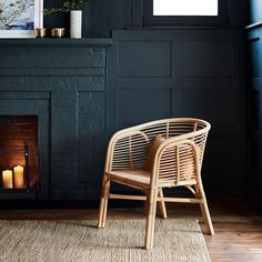 a wicker chair sitting in front of a fireplace