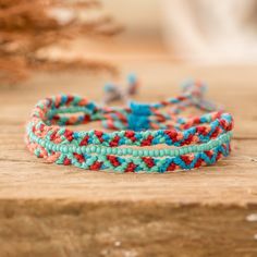 three different colored bracelets sitting on top of a wooden table