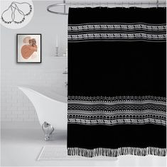 a bath tub sitting next to a shower curtain in a white bathroom with black and white decor