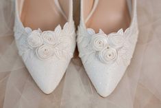 white wedding shoes with flowers and pearls on them